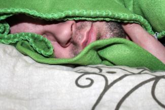 schlafender Mann unter Decke