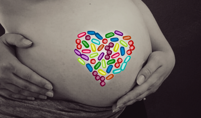 Schwangere Frau mit Herz aus Bakterien.