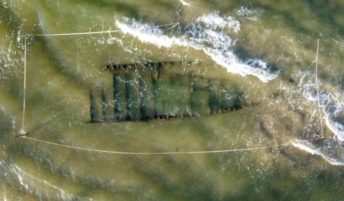 Vue aérienne d'une épave vieille de plusieurs siècles, découverte après le passage du typhon Kalmaegi, sur une plage au large de Hoi An, dans le centre du Vietnam, le 9 novembre 2025