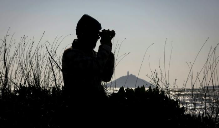 L'ornithologue Sean Ronayne observe des oiseaux avec des jumelles, sur la plage de Ballycotton, près de Cobh, le 3 avril 2025 en Irlande
