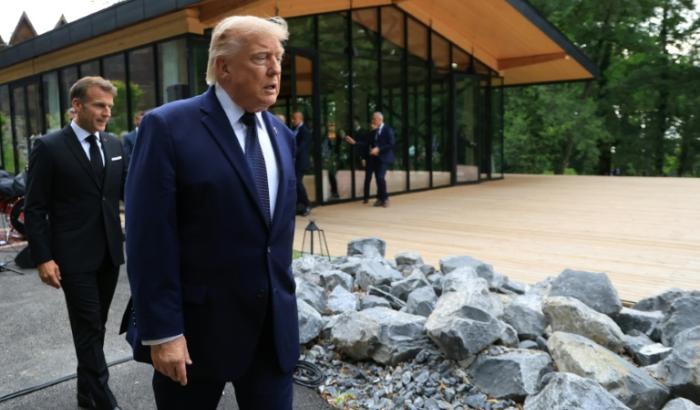 Le président américain Donald Trump (au centre) arrive aux côtés du président français Emmanuel Macron avant la prise d'une photo de groupe lors d'un dîner de gala organisé dans le cadre du G7, à Evian, en Haute-Savoie, le 16 juin 2026