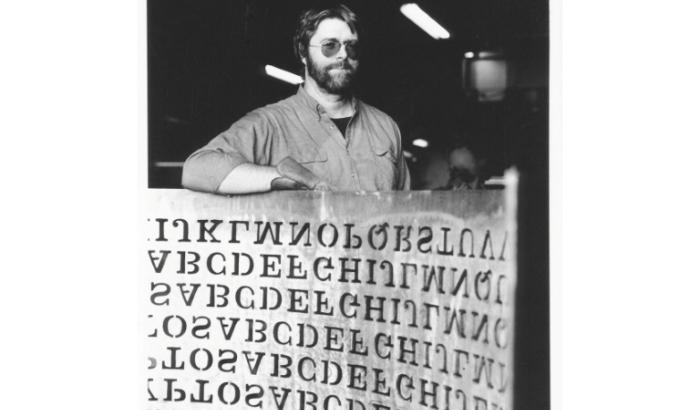 Cette photo de 1990, fournie par Jim Sanborn, montre le sculpteur Jim Sanborn avec un bout de sa sculpture en cuivre "Kryptos", installée au siège de la CIA, en Virginie, aux Etats-Unis