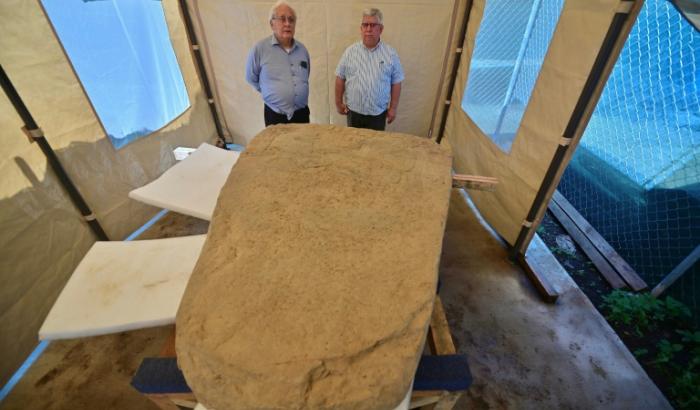 Les archéologues Lino Espinoza (g) et Alberto Vazquez (d) près d'une stèle de 2,5 tonnes découverte sur un site archéologique à Coatepec, au Mexique, le 18 juin 2026