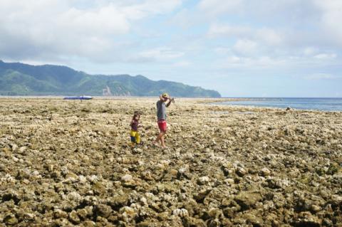 Des personnes marchent sur des coraux remontés à la surface à la suite d'un soulèvement côtier provoqué par un tremblement de terre le long de la réserve marine de Pangyan, à Glan, dans la province de Sarangani, à Mindanao, aux Philippines, le 18 juin 2026