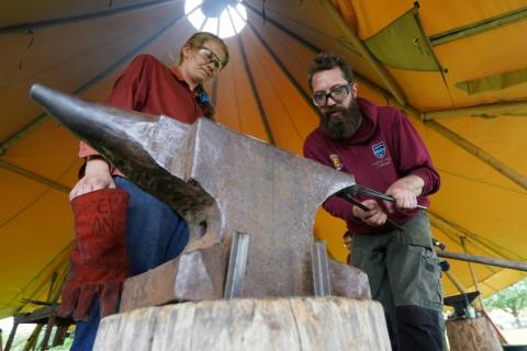 Mischa Kunckel (g) et Rowan Taylor de l'école nationale britannique de forgeage martèlent le fer contre une enclume près du musée des navires vikings à Roskilde, au Danemark, le 28 mai 2024