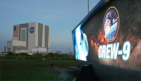 Un écran annonçant la mission de SpaceX Crew-9 devant le bâtiment d'assemblage des fusées de la Nasa, au Centre spatial Kennedy en Floride le 28 septembre 2024