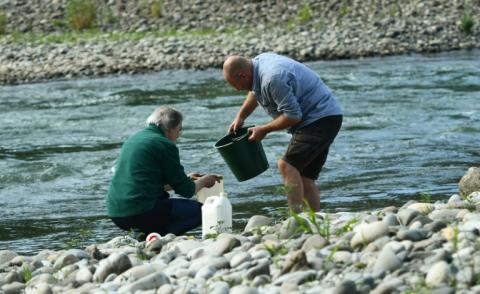 Le biologiste François Lefebvre (droite) et l'hydrogéologue Thierry Alezine cherchent des niphargus, des micro-crustacés, sur les rives du Gave de Pau à Artiguelouve, dans le sud-ouest de la France, le 21 août 2024