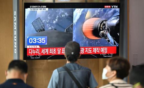 Un écran géant diffuse des images de la fusée Falcon 9 transportant la première sonde lunaire sud-coréenne, le 5 août 2022 dans une gare de Séoul