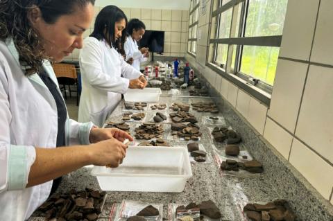 Photo diffusée par WLage Arqueologia montrant des archéologues examinant des fragments de céramique trouvés lors de fouilles sur un chantier de construction à Sao Luis, dans l'État du Maranhao, le 29 mars 2023 au Brésil