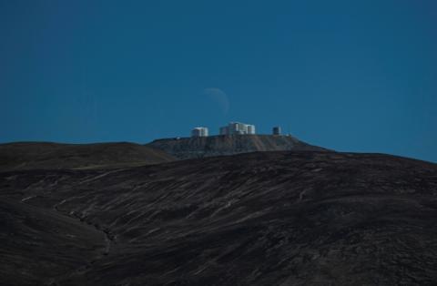 Le dernier quartier de lune se couche derrière la plateforme du Very Large Telescope (VLT), à l'Observatoire européen austral (ESO) de Paranal dans le désert d'Atacama, à environ 1.150 km au nord de Santiago du Chili, le 21 juin 2022