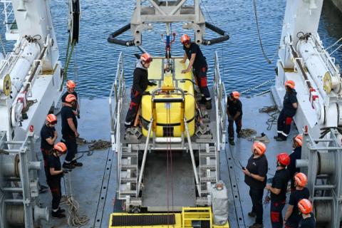 Des techniciens effectuent un test de lancement du robot sous-marin Ulyx à bord du navire scientifique Atalante amarré au port de Brest avant son départ, le 15 juin 2025 dans le Finistère
