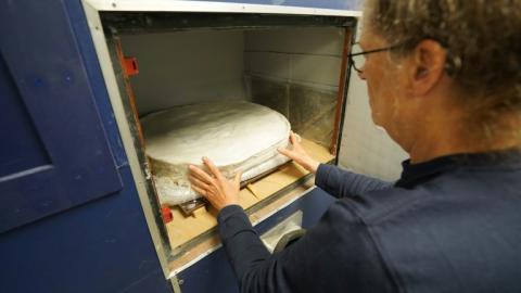 La conservatrice Helle Strehle place un cercueil préservé de l'ère viking découvert à Lisbjerg dans un appareil à rayons X dans les laboratoires du musée Moesgaard à Aarhus, au Danemark, le 13 juin 2025