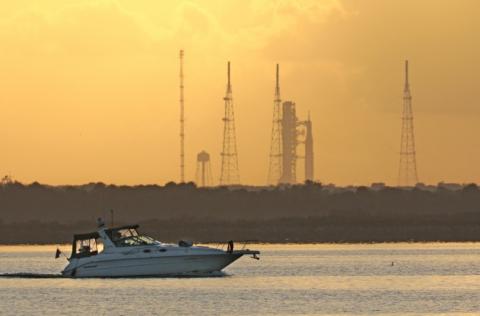 Un bateau passe au large de la fusée SLS Artémis 2 de la Nasa au Centre spatial Kennedy, au lever du soleil à Cap Canaveral, en Floride, le 1er avril 2026