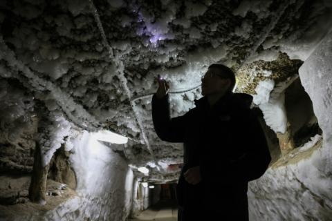 Un scientifique examine les formes de glace qui sortent du pergélisol dans un tunnel souterrain à l'Institut du pergélisol à Iakuutsk, le 28 mars 2025 en Sibérie orientale