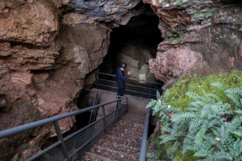 Le paléoanthropologue Lee Berger devant la principale entrée du système de grottes Rising Star du "Berceau de l'humanité", au nord-ouest de Johannesburg, le 11 mai 2023