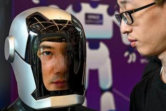 Un visiteur observe un robot humanoïde lors de l'édition 2024 du Salon des concepteurs de robots humanoïdes, à Shanghai (Chine) le 6 juin 2024.