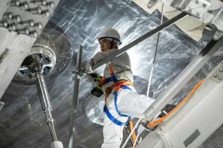 Un ouvrier travaillant sur la structure du détecteur de neutrinos, une sphère en acier inoxydable et en acrylique d'environ 35 mètres de diamètre, à l'observatoire souterrain de neutrinos de Jiangmen (Juno) à Kaiping, dans la province méridionale du Guangdong, en Chine, le 11 octobre 2024