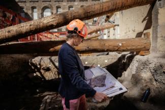 Une archéologue de la Ville de Paris examine le plan du site archéologique où un mur de Lutèce datant de l'époque gallo-romaine, a été découvert sous l'Hôtel-Dieu, dans le centre de Paris, le 23 septembre 2026