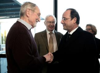 Martin Karplus (à gauche), prix Nobel de chimie en 2013, salue le président de la République François Hollande (à droite), devant un autre prix Nobel de chimie, Jean-Marie Lehn (1987), le 30 janvier 2014 à Strasbourg