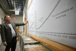 Le scientifique Tim Lueker montre un graphique représentant la courbe de Keeling, un indicateur majeur du changement climatique, le 11 avril 2025, à San Diego en Californie